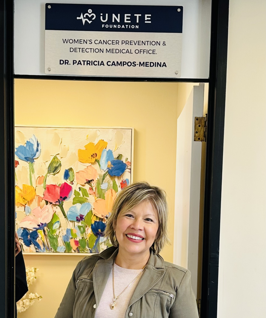 Dr. Patricia Campos-Medina smiling at the entrance of the UNETE Foundation’s Women’s Cancer Prevention & Detection Medical Office.
