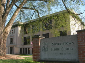 Exterior view of Morristown High School in New Jersey with the school sign in front of the building.